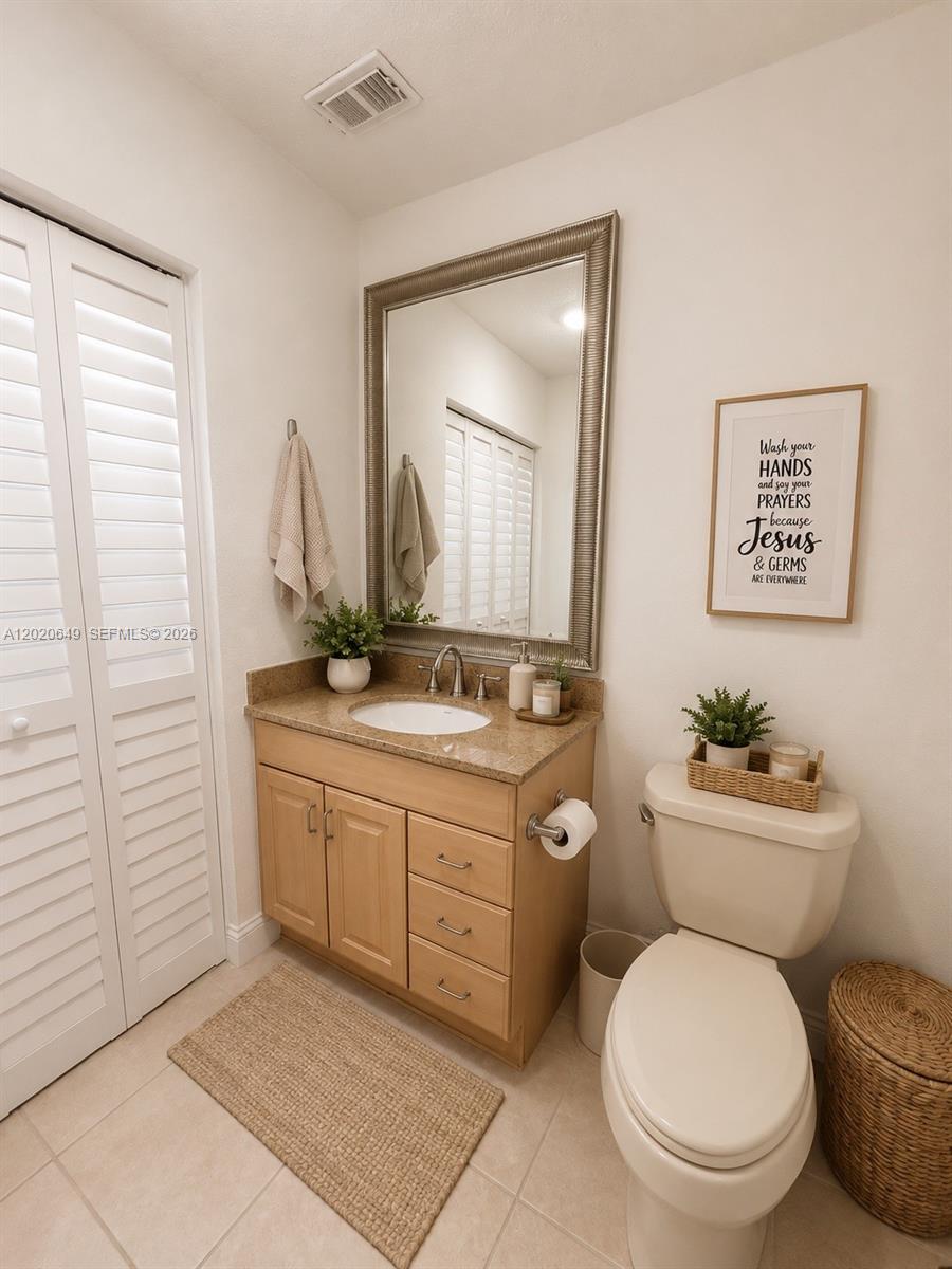 A bathroom features a vanity with a granite countertop, a mirror, and a toilet — 12805 SW 116th Ct # 1, Miami FL 33176, MIAMI, FL