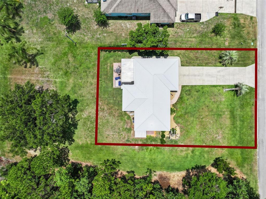 A single-story house with a white roof and a palm tree in the front yard — 7651 LIMONIA DRIVE, INDIAN LAKE ESTATES, FL