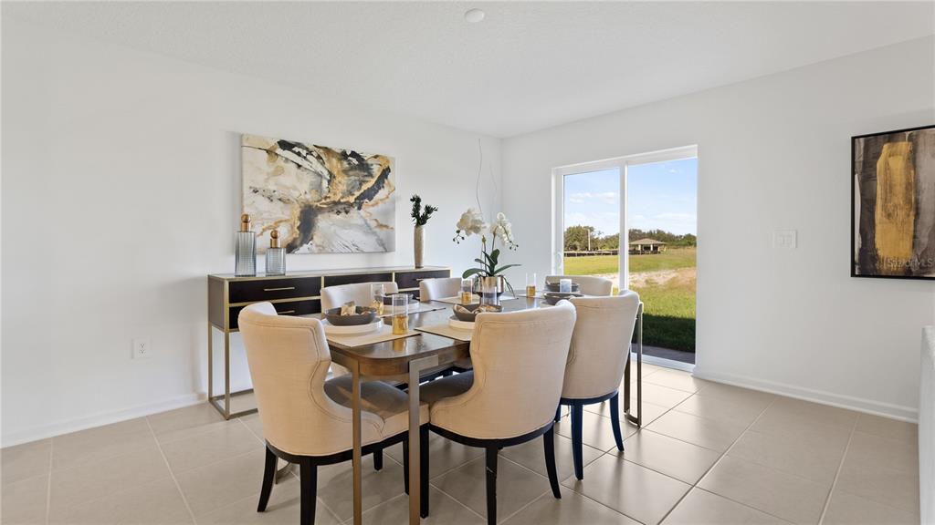 A dining room with a table, four chairs, a sideboard, and sliding glass patio doors — 1950 PINE MEADOWS GOLFCOURSE ROAD, EUSTIS, FL