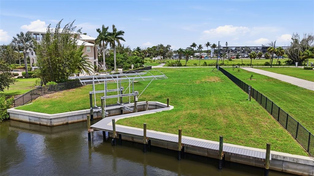 An aerial view shows a vacant waterfront lot with a boat lift and dock — 1947 WISCONSIN AVENUE, ENGLEWOOD, FL