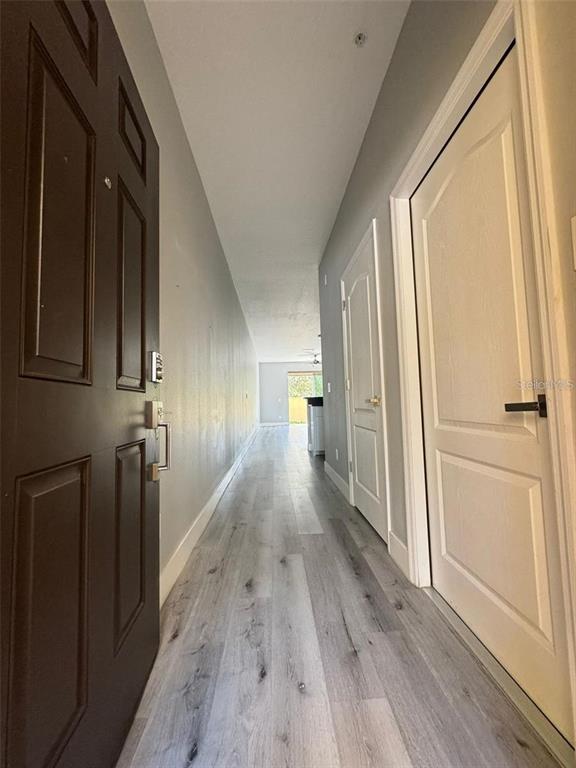 A long hallway with light wood-look flooring leads toward an open living area — 14442 DESERT HAVEN STREET UNIT 4305, WINDERMERE, FL