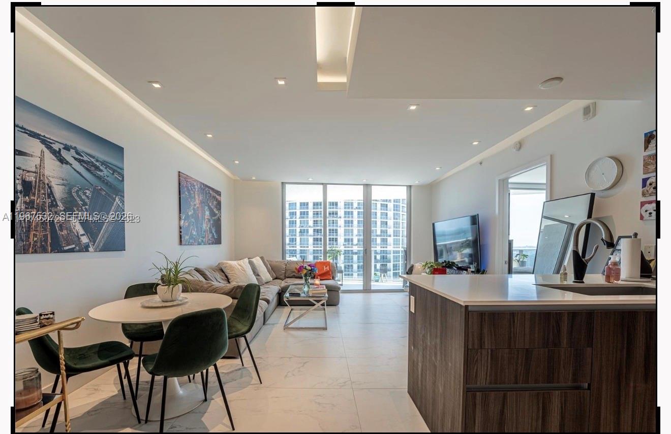 A modern living room and dining area with white tile floors and floor-to-ceiling windows — 488 NE 18th St # 4304, Miami FL 33132, MIAMI, FL