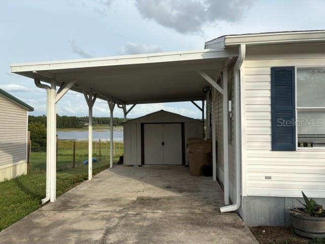 A white single-story house with blue shutters and a wooden deck under a cloudy sky — 13225 PLUM LAKE CIRCLE, MINNEOLA, FL