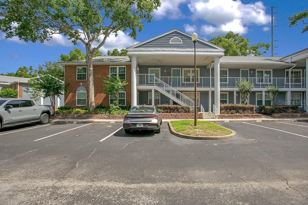 A two-story apartment building with a parking lot in the foreground — 5449 LAKE MARGARET DRIVE UNIT 86, ORLANDO, FL
