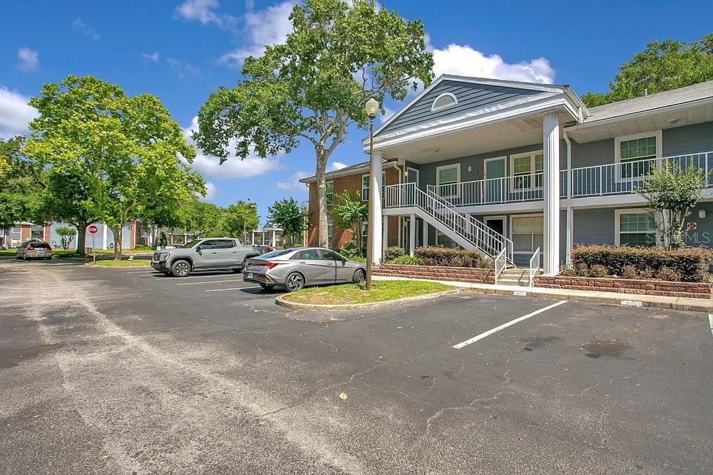 A two-story apartment building with a parking lot and a staircase in the front — 5449 LAKE MARGARET DRIVE UNIT 86, ORLANDO, FL