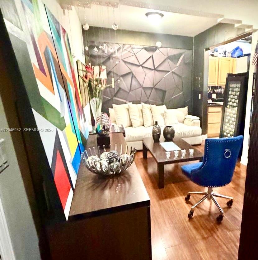 A living room features a geometric accent wall, a white sofa, and a blue chair — 750 Jefferson Ave # 4, Miami Beach FL 33139, MIAMI BEACH, FL