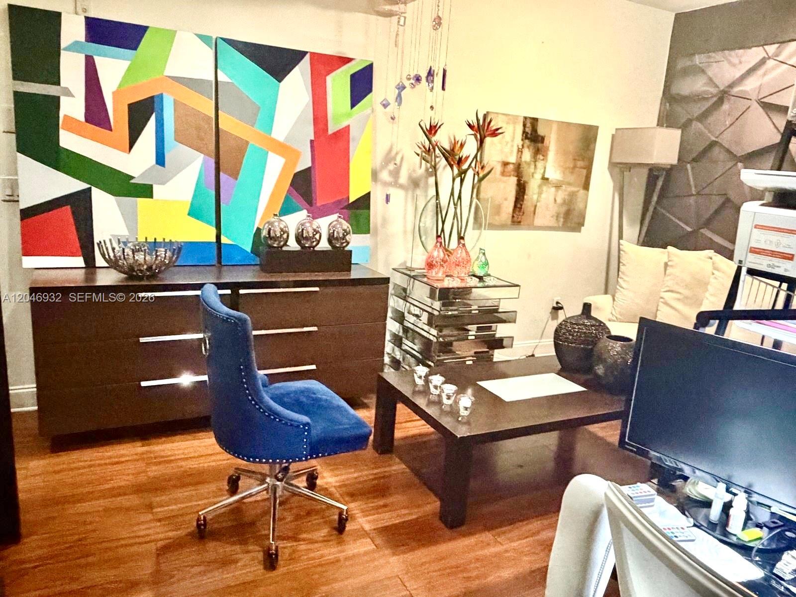 A home office features a blue velvet chair, a dark wood desk, and abstract wall art — 750 Jefferson Ave # 4, Miami Beach FL 33139, MIAMI BEACH, FL