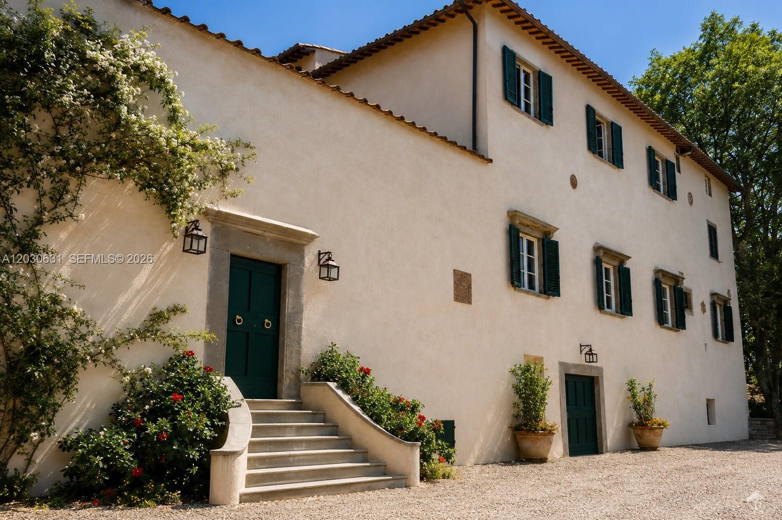 A beige stucco villa features green shutters, a stone staircase, and a dark green door — Tuscany Luxury Estate Florence Max Mlekus, FL