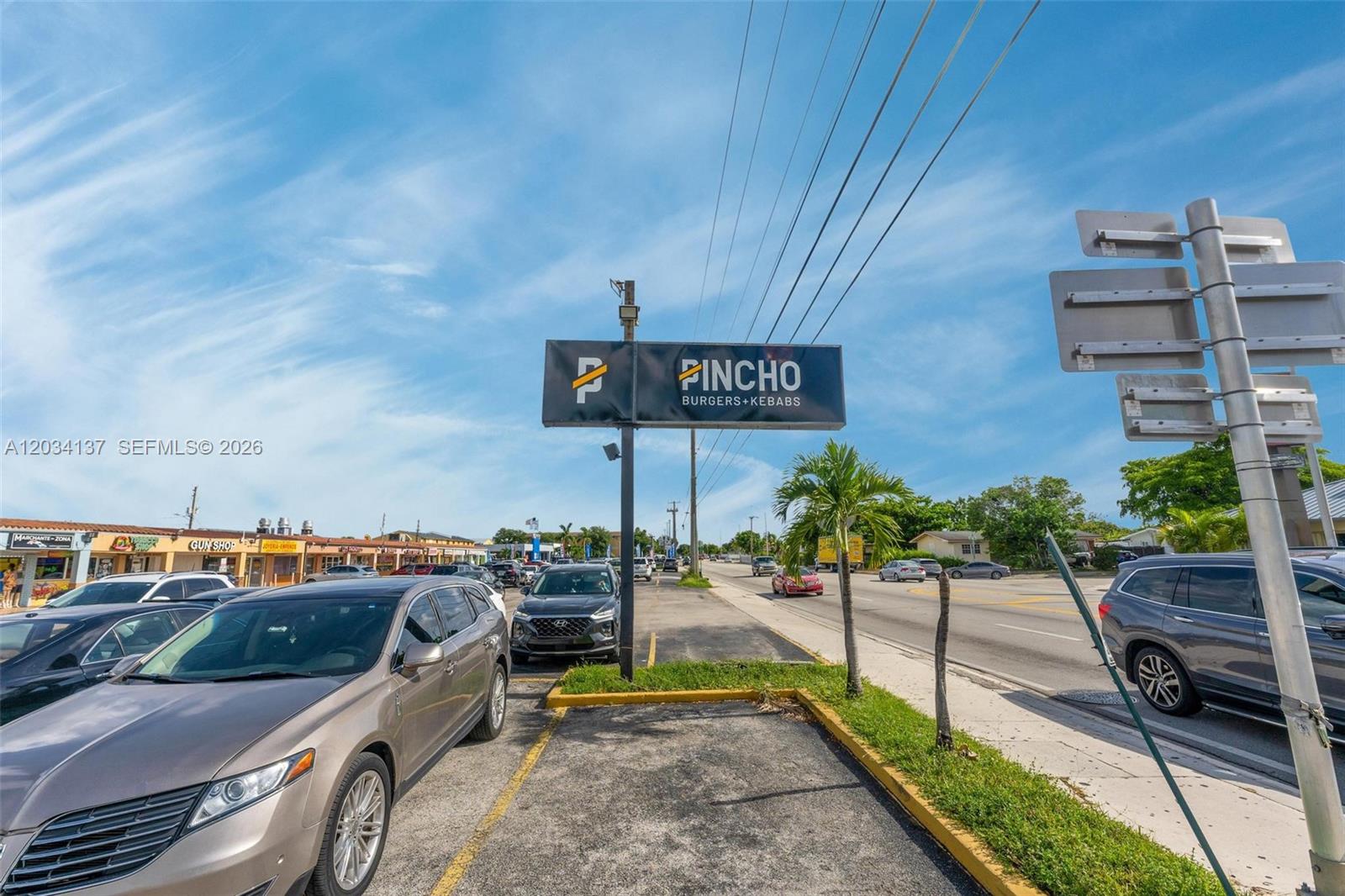 A parking lot in front of a Pincho Burgers + Kebabs restaurant sign — 4950 W 12th Ave, Hialeah FL 33012, HIALEAH, FL