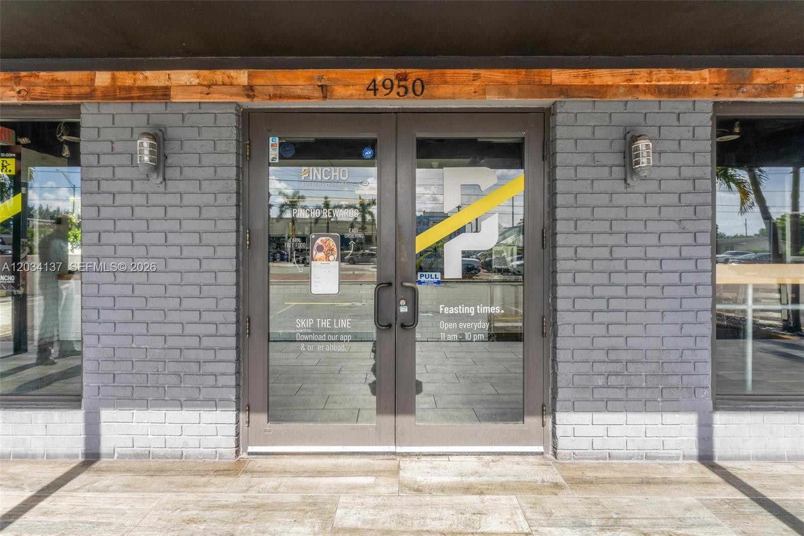 The exterior of a restaurant features double glass doors with signage set in a brick wall — 4950 W 12th Ave, Hialeah FL 33012, HIALEAH, FL
