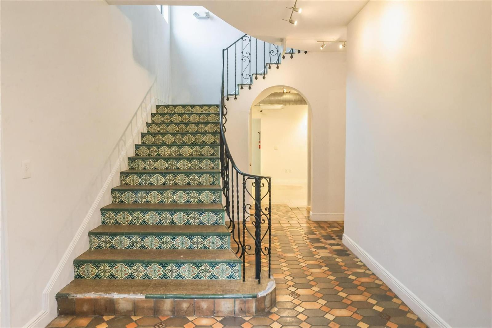 A staircase with patterned tile risers and a wrought iron railing leads to an upper level — 445 NE 56, Miami FL 33137, MIAMI, FL