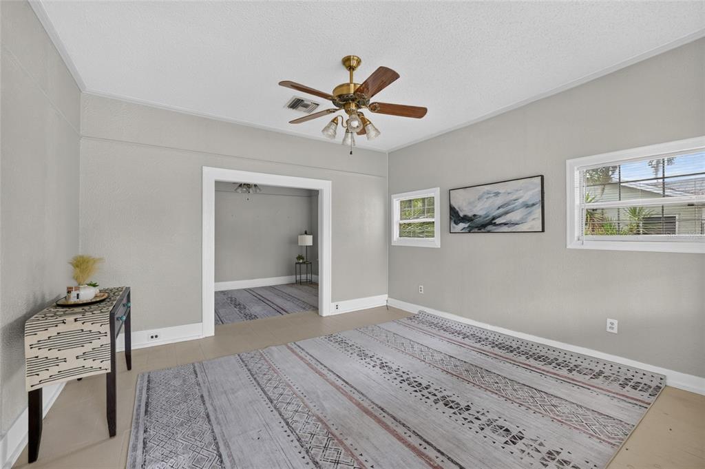 A living room with gray walls, a ceiling fan, and a large patterned area rug — 926 NE 8TH AVENUE, OCALA, FL