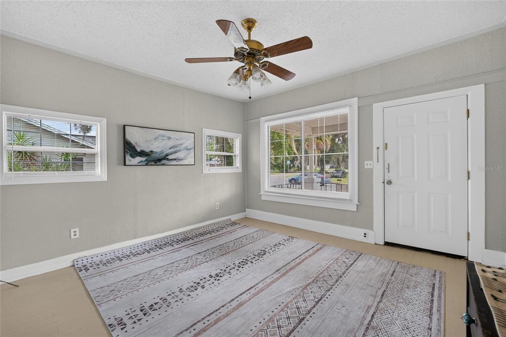A living room with light gray walls, a patterned area rug, and a ceiling fan — 926 NE 8TH AVENUE, OCALA, FL
