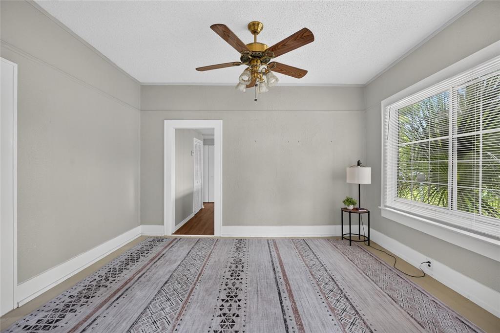 A bedroom with gray walls, a patterned area rug, a ceiling fan, and a window — 926 NE 8TH AVENUE, OCALA, FL