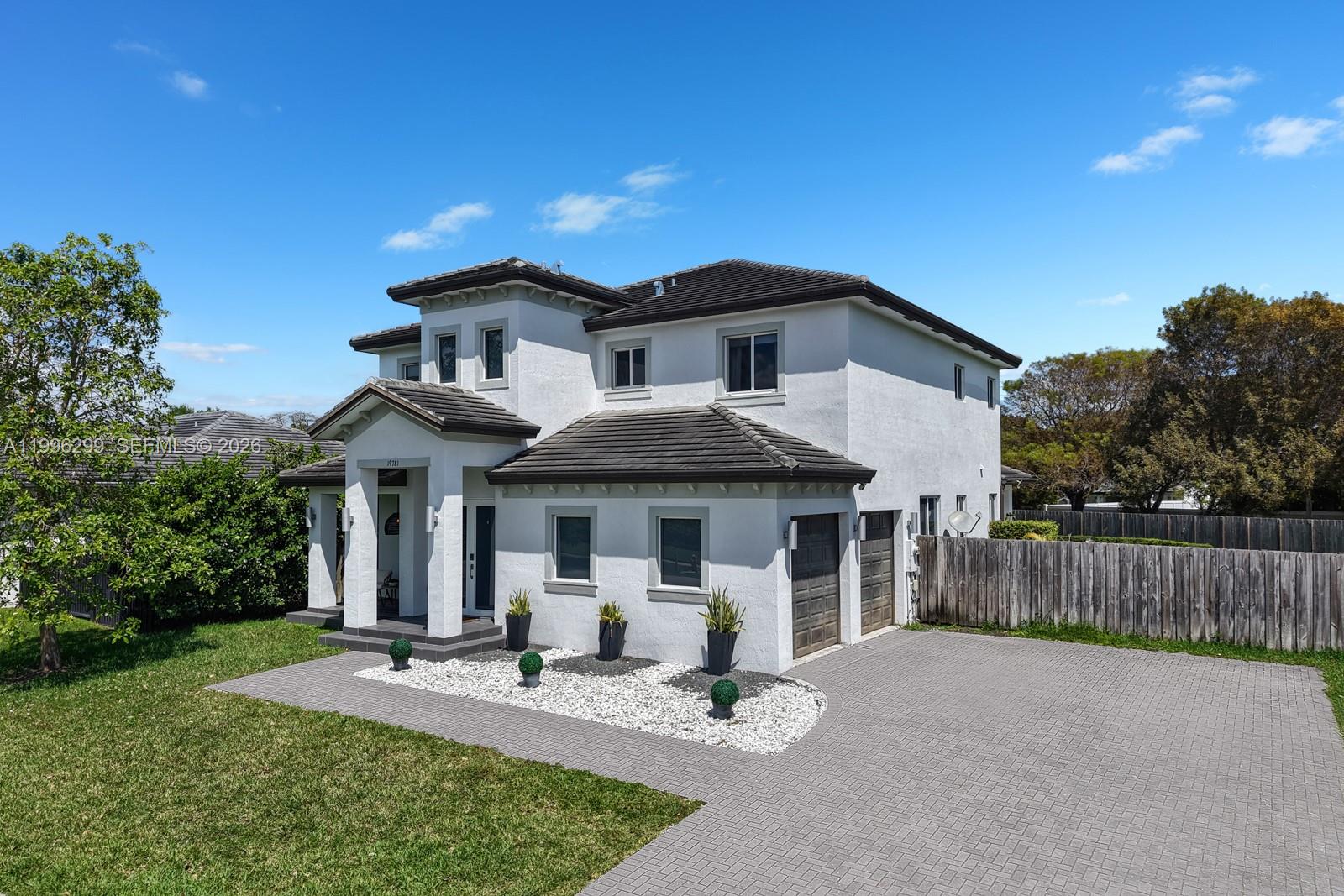 A two-story white stucco house features a tiled roof, a paved driveway, and landscaping — 19781 SW 84th Ct, Cutler Bay FL 33189, CUTLER BAY, FL