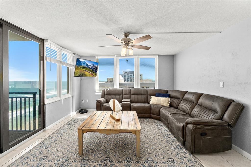 A living room features a large sectional sofa, a wooden coffee table, and ocean views — 2947 S ATLANTIC AVENUE UNIT 1903, DAYTONA BEACH, FL