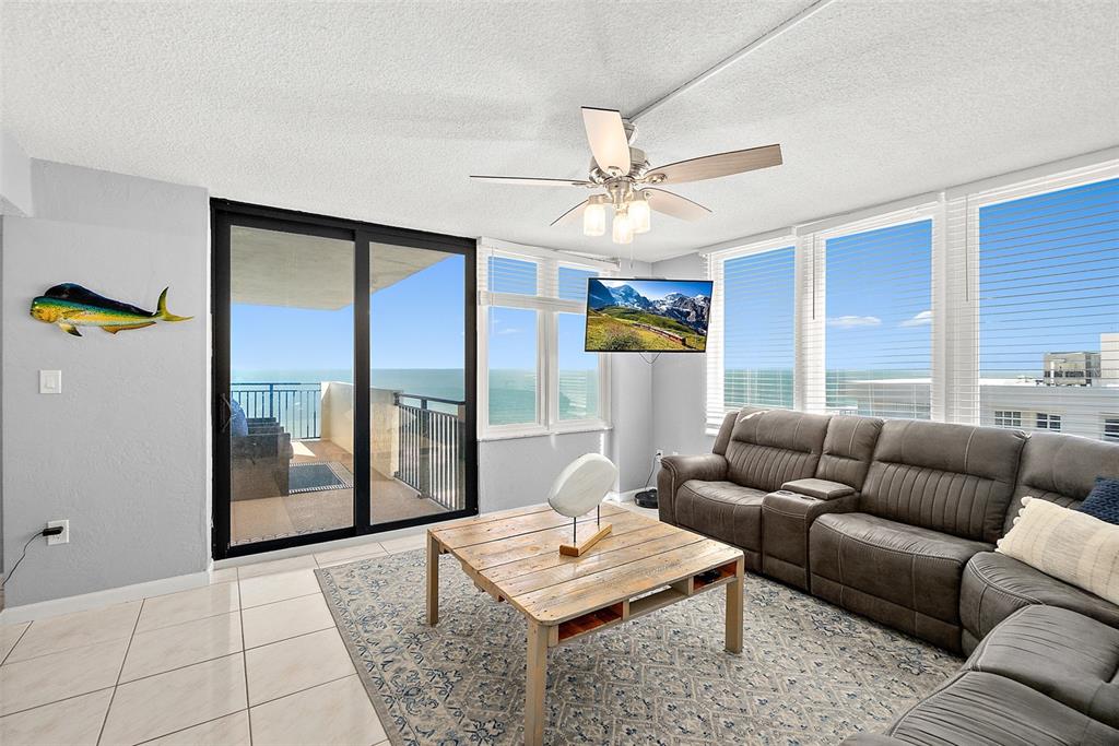 A living room features a gray sectional sofa, a wooden coffee table, and ocean views — 2947 S ATLANTIC AVENUE UNIT 1903, DAYTONA BEACH, FL