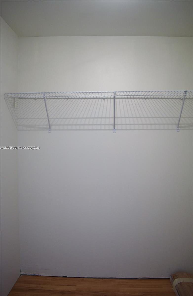 An empty closet features a white wire shelf and light wood flooring — 3339 Virginia St # 207, Miami FL 33133, MIAMI, FL