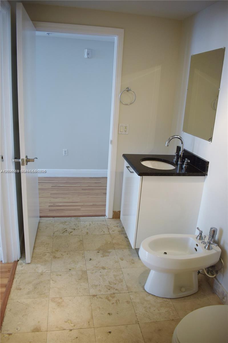 A bathroom features a vanity with a dark countertop, a bidet, and tile flooring — 3339 Virginia St # 207, Miami FL 33133, MIAMI, FL