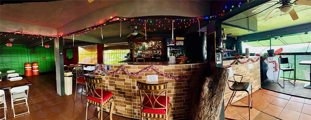 A bar area features brick counters, bar stools, festive lighting, and an outdoor patio view — 149 ROUTE UNIT KM 18.3, CIALES, PR