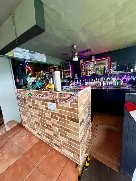 A brick-fronted bar counter sits in a room with tile flooring and a ceiling fan — 149 ROUTE UNIT KM 18.3, CIALES, PR