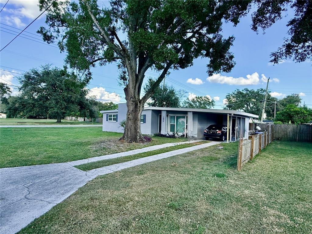 A single-story house with a carport and a large tree in the front yard — 1604 CRYSTAL COURT E, LAKELAND, FL