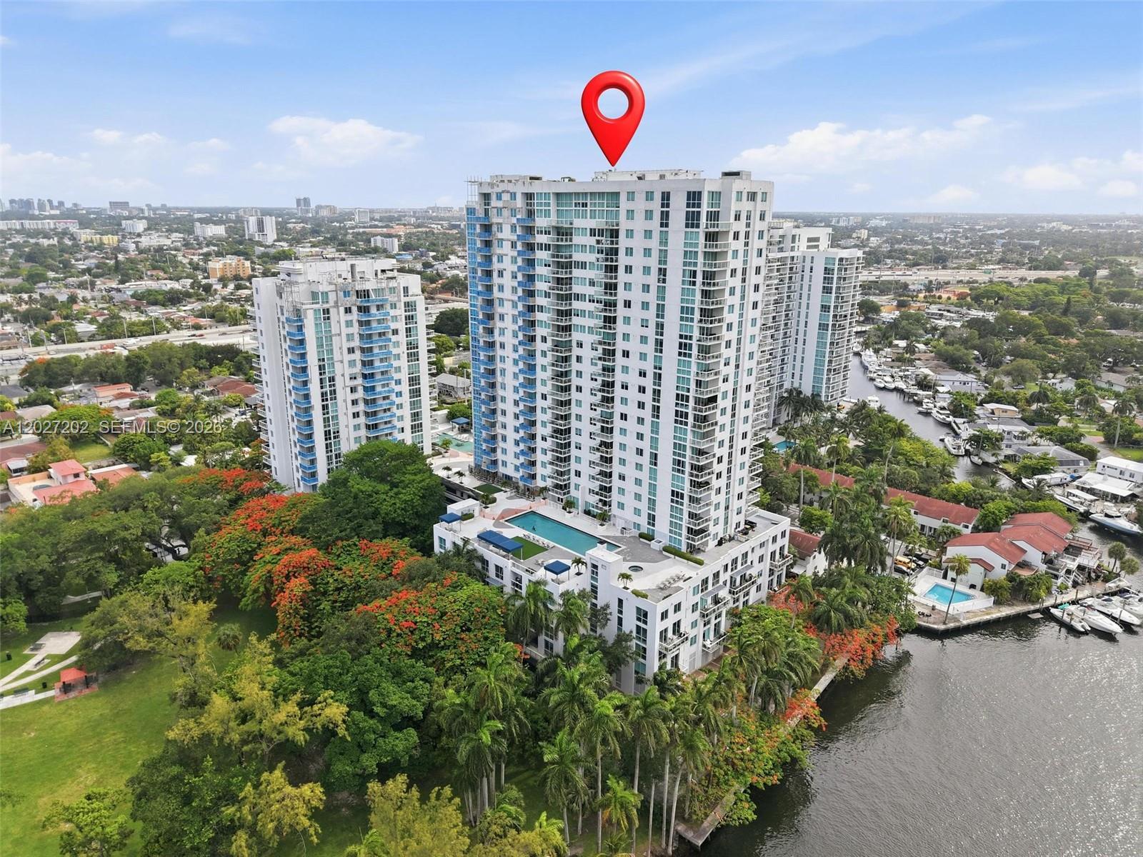 An aerial view shows a tall residential high-rise building situated next to a waterway — 1861 NW S River Dr # 2008, Miami FL 33125, MIAMI, FL