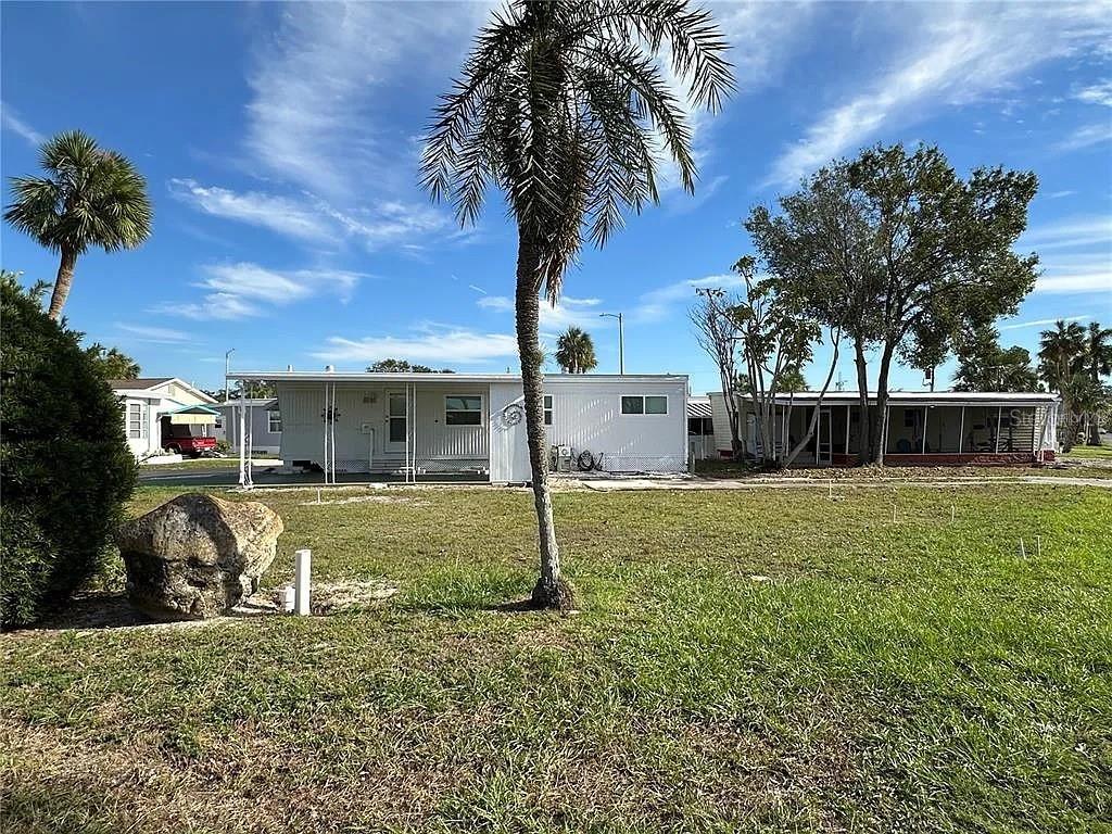 A white mobile home with a palm tree in the front yard — 4851 W GANDY BOULEVARD UNIT B5L37, TAMPA, FL
