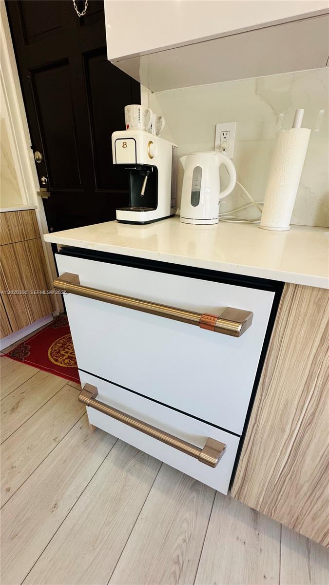 A white dishwasher with gold handles sits under a countertop with a coffee maker — 1670 SW 20th St # 2, Miami FL 33145, MIAMI, FL