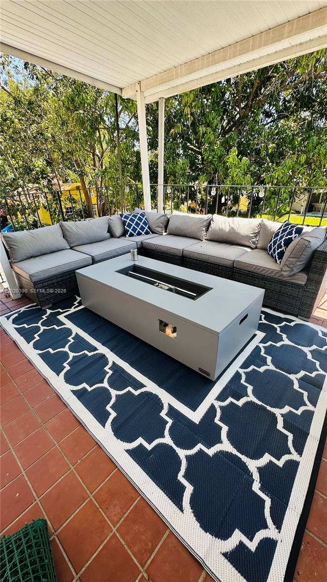 A covered patio features a gray sectional sofa, a rectangular fire pit, and a patterned rug — 1670 SW 20th St # 2, Miami FL 33145, MIAMI, FL