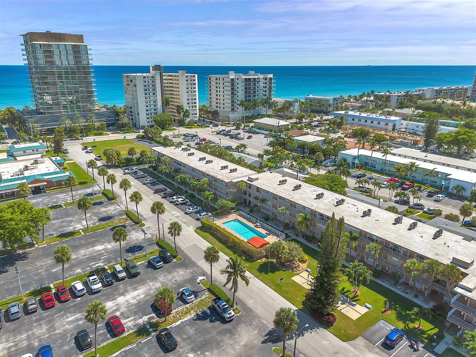 An aerial view shows a multi-story apartment complex with a pool and adjacent parking lots — 3200 NE 7th Court # 202b, Pompano Beach FL 33062, POMPANO BEACH, FL