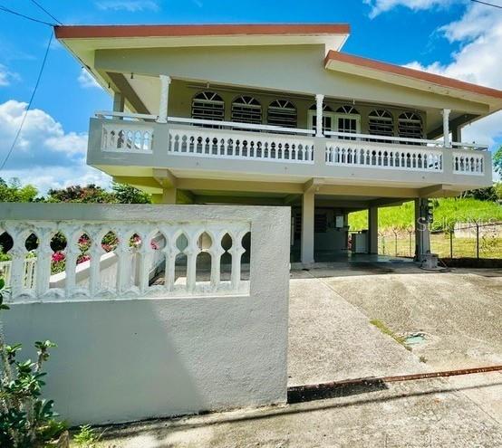 A two-story house with a white balcony railing and an open-air ground level — Bo Ceiba Sur Sector Canal SOLAR #6, JUNCOS, PR