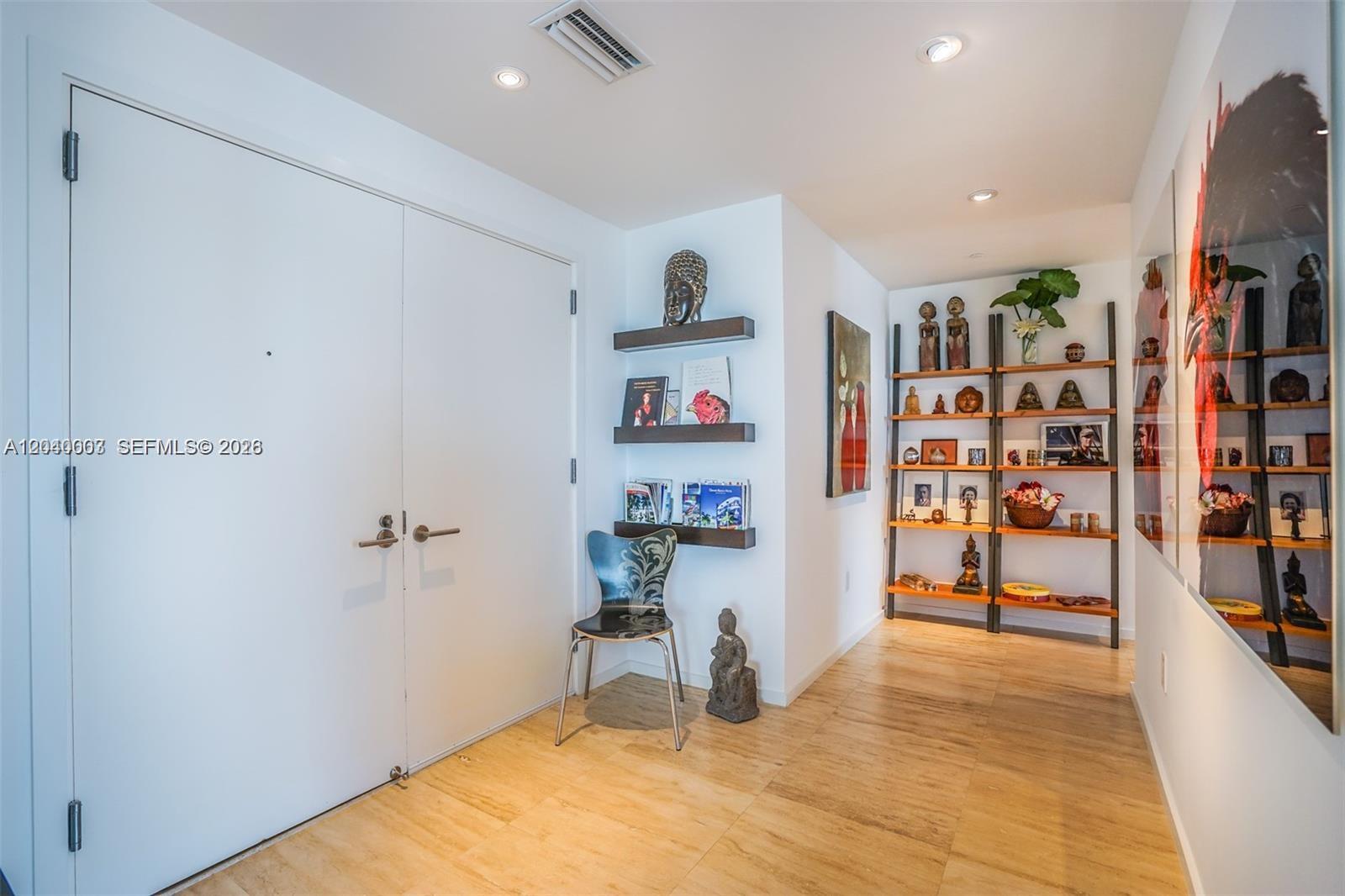 A bright entryway features light wood flooring, double white doors, wall shelves, and open shelving — 1445 16th St # 1103, Miami Beach FL 33139, MIAMI BEACH, FL