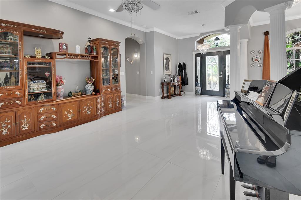A bright foyer features white tile floors, a grand piano, and a large wooden wall unit — 6241 PALOMINO CIRCLE, PORT ORANGE, FL