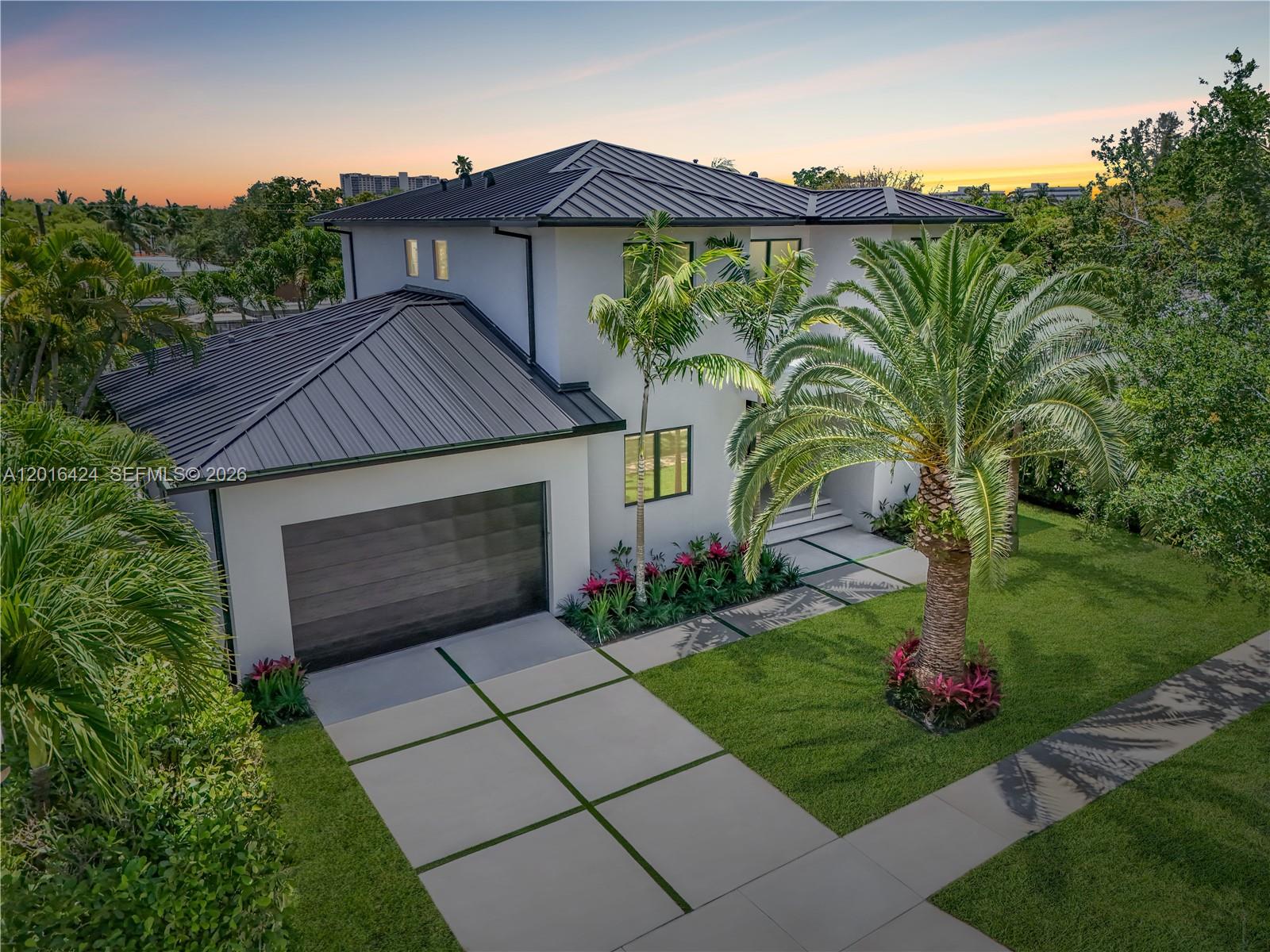 An aerial view of a two-story modern house with a metal roof and palm trees — 1940 Alamanda Dr, North Miami FL 33181, NORTH MIAMI, FL