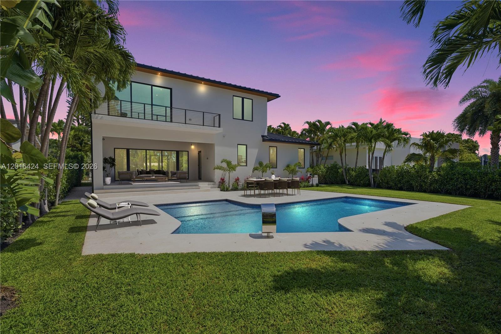 A two-story house features a backyard with a swimming pool, patio, and outdoor dining area — 1940 Alamanda Dr, North Miami FL 33181, NORTH MIAMI, FL