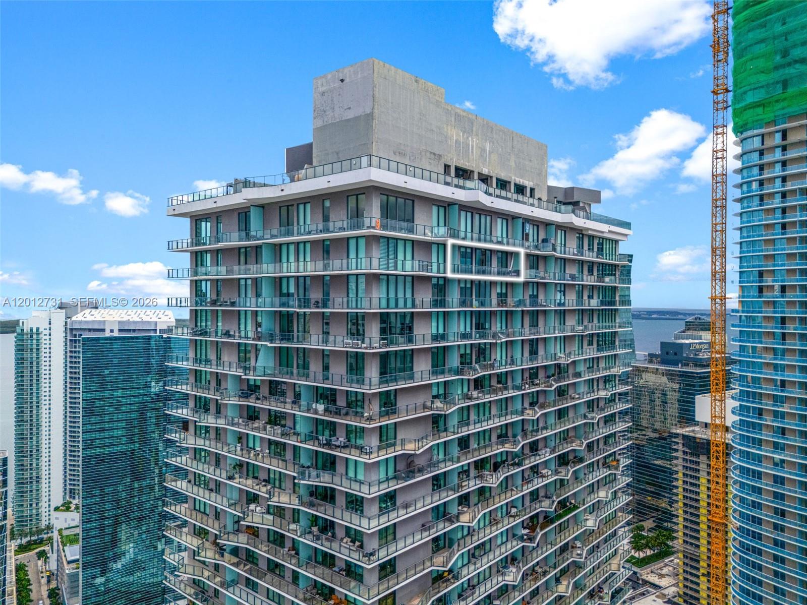 An exterior view of a high-rise residential building with balconies and a highlighted unit — 1300 S Miami Ave, Miami FL 33130, MIAMI, FL