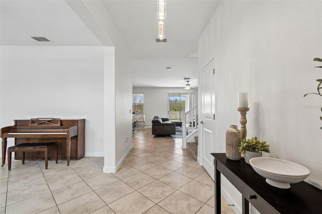 A tiled entryway leads to a living area with a piano and a console table — 8960 SHADYSIDE LANE, LAND O LAKES, FL