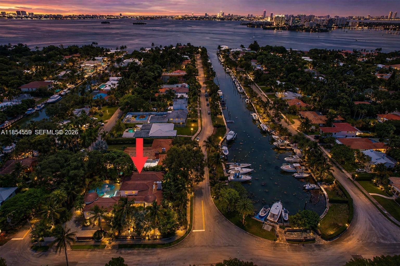 A two-story house exterior at dusk featuring a swimming pool, patio, and palm trees — 1051 NE 89th St, Miami FL 33138, MIAMI, FL