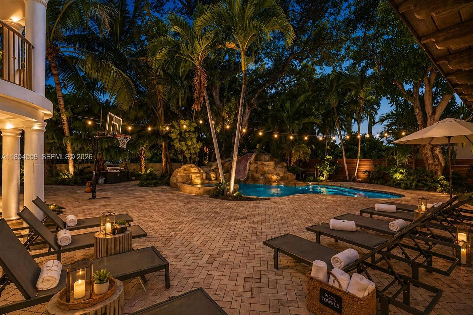 An aerial view shows a waterfront residential property with a pool and boat dock at dusk — 1051 NE 89th St, Miami FL 33138, MIAMI, FL