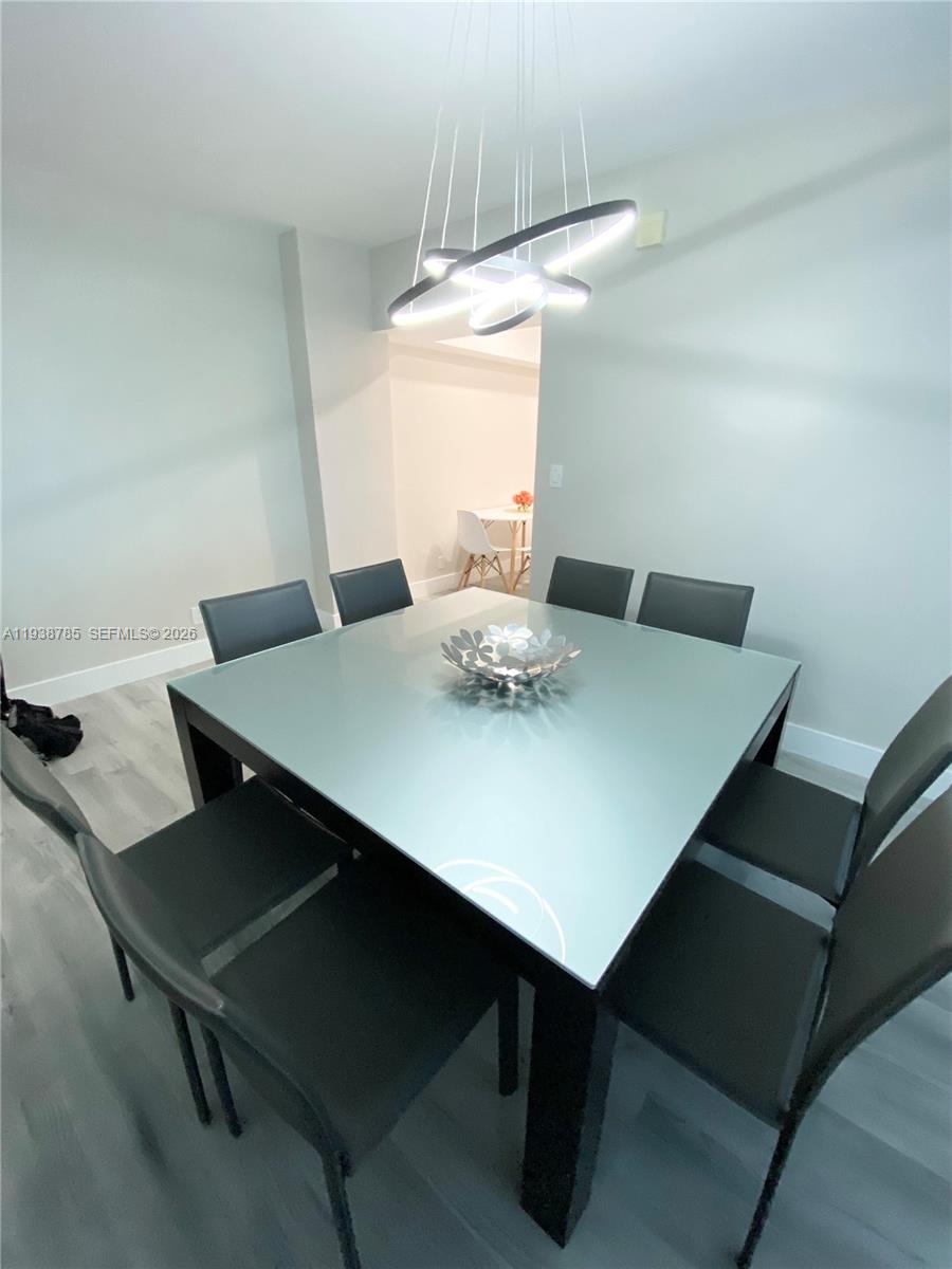 A dining room features a square glass-topped table surrounded by eight black chairs — 4001 S Ocean Dr # 4M, Hollywood FL 33019, HOLLYWOOD, FL