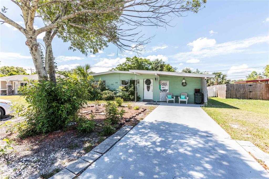 A light green single-story house with a concrete driveway and a covered front porch — 5344 TANGERINE DRIVE, NEW PORT RICHEY, FL