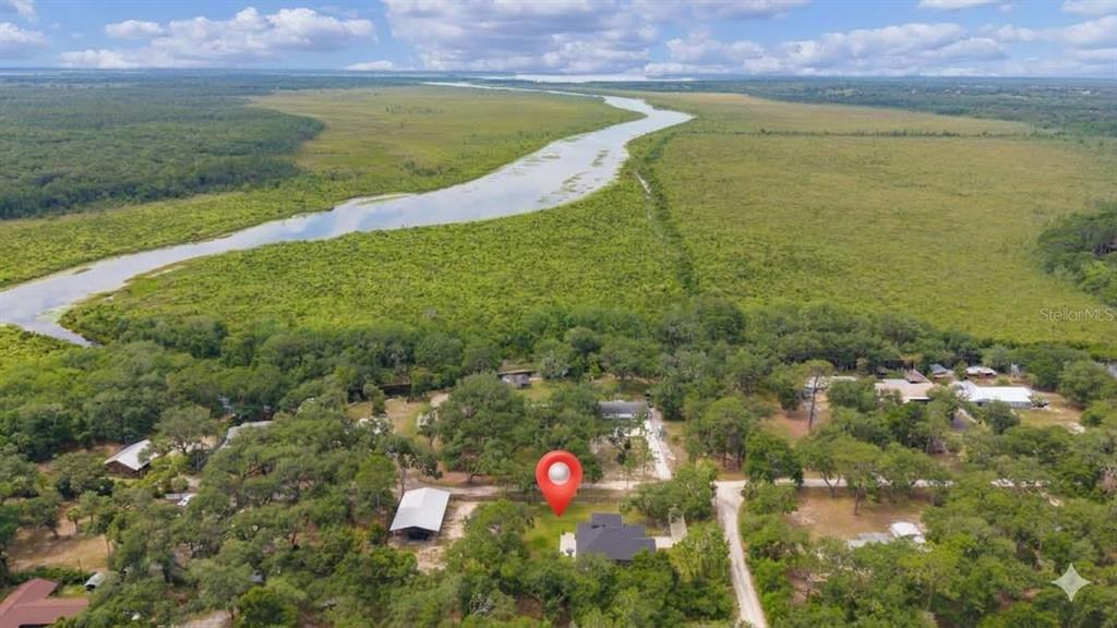 An aerial view shows a house with a red location pin near a winding river — 16189 SE 190TH AVENUE, WEIRSDALE, FL