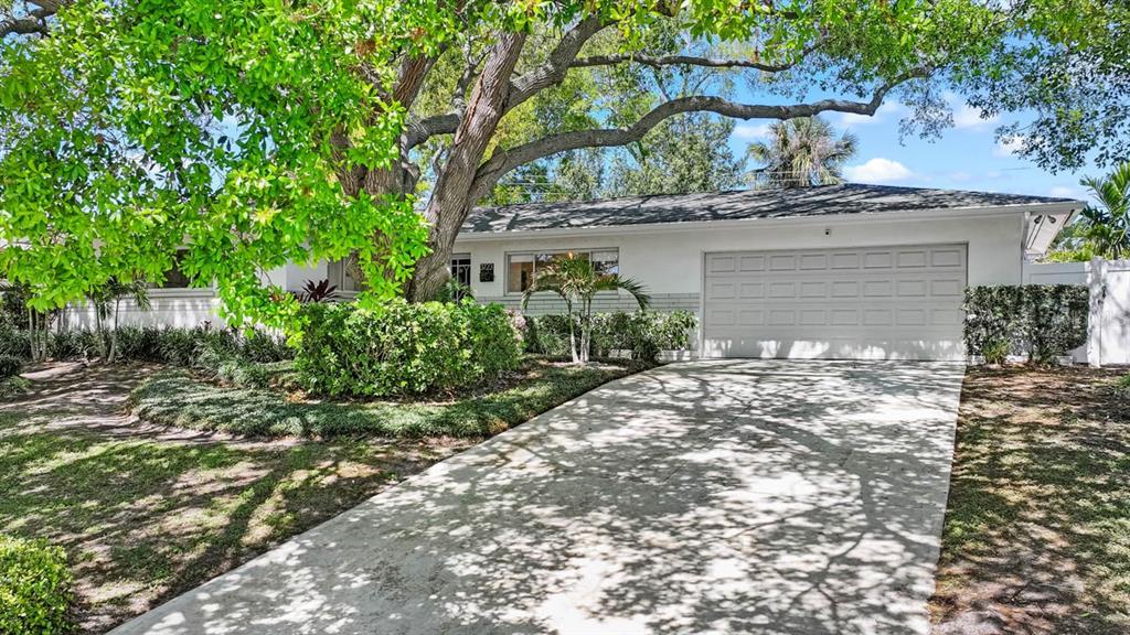 A single-story house with a white exterior, a two-car garage, and a large shade tree — 3723 ORCHARD GROVE LANE, LARGO, FL