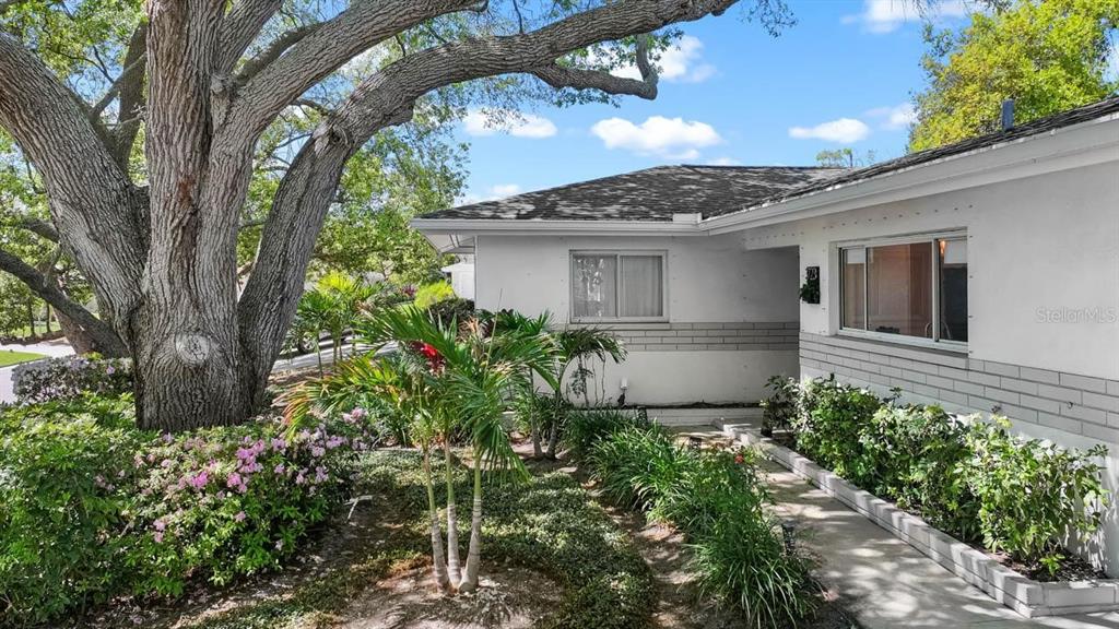 An entryway features a teal door, a black storage unit, and a round wall mirror — 3723 ORCHARD GROVE LANE, LARGO, FL