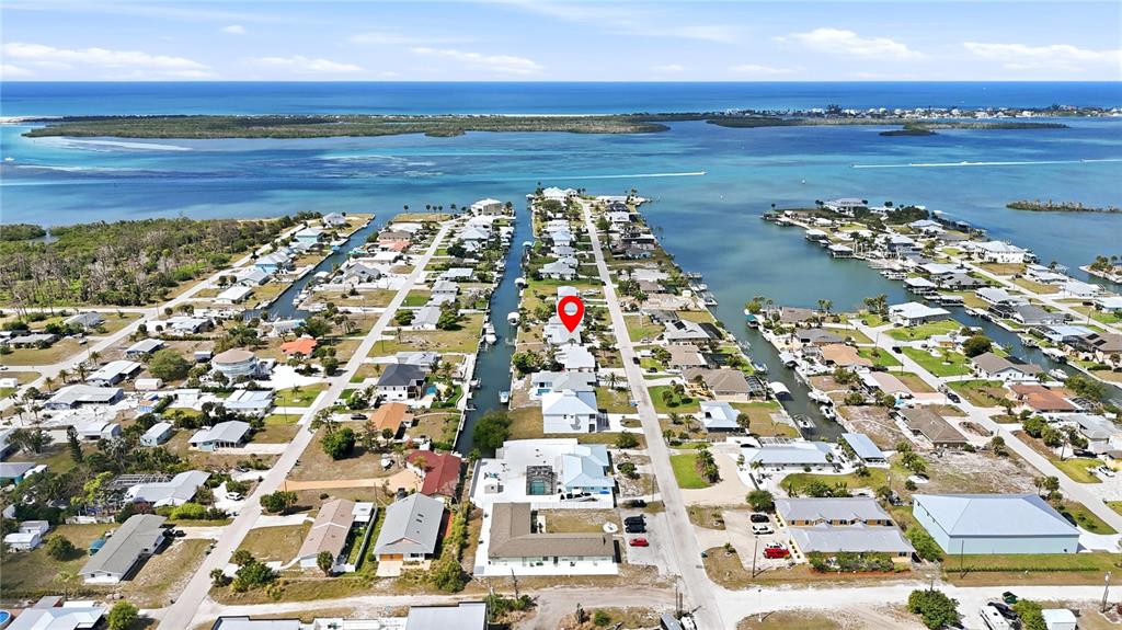 This aerial view shows a coastal neighborhood with houses situated along narrow canals — 1959 MISSISSIPPI AVENUE, ENGLEWOOD, FL