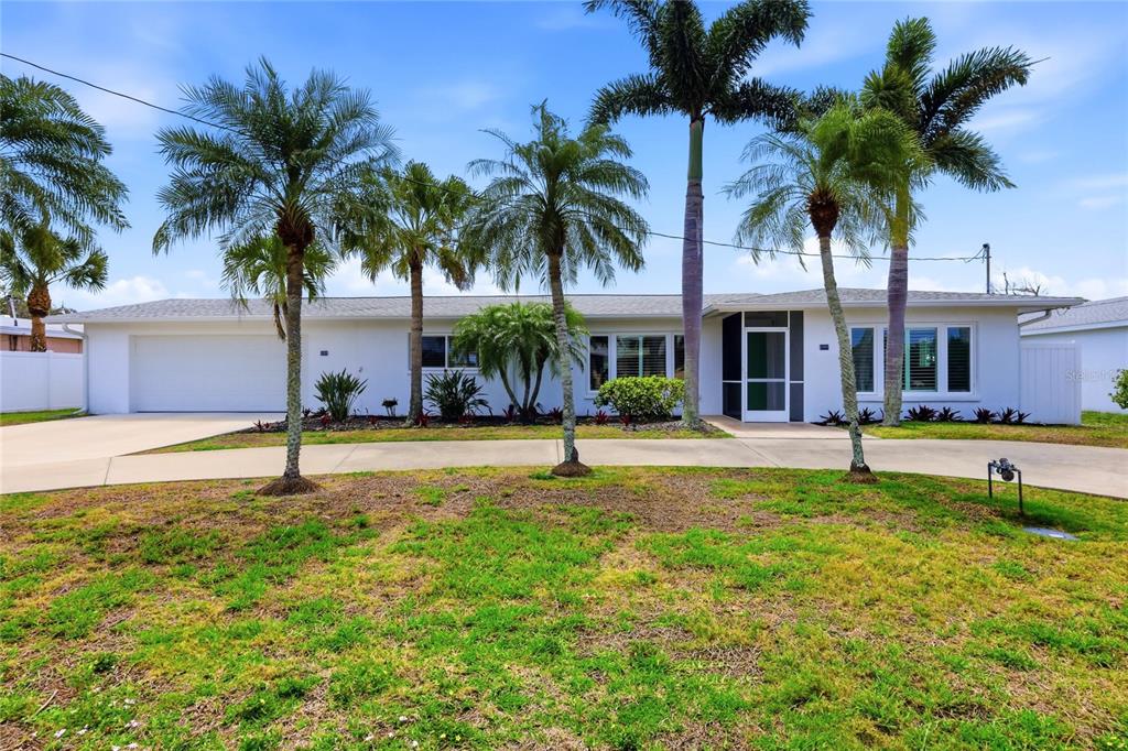 A single-story white house with a curved driveway and several palm trees in the front — 1959 MISSISSIPPI AVENUE, ENGLEWOOD, FL