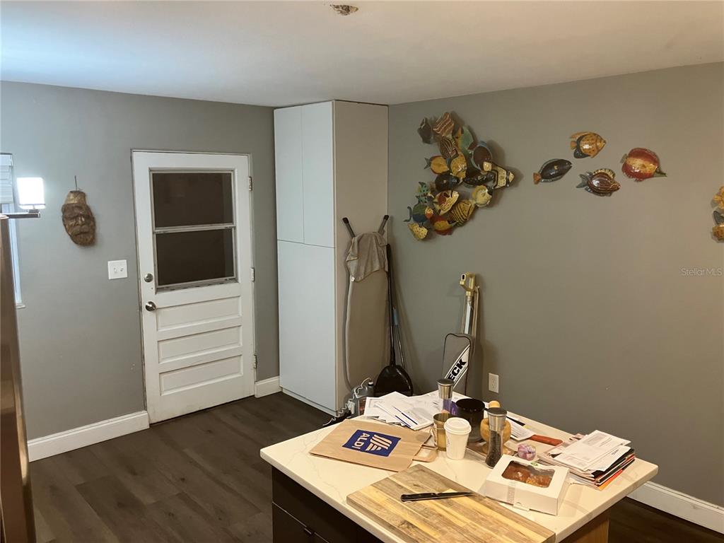 A kitchen features gray walls, dark wood-look flooring, a white door, and a central island — 4409 19TH STREET CIRCLE W, BRADENTON, FL