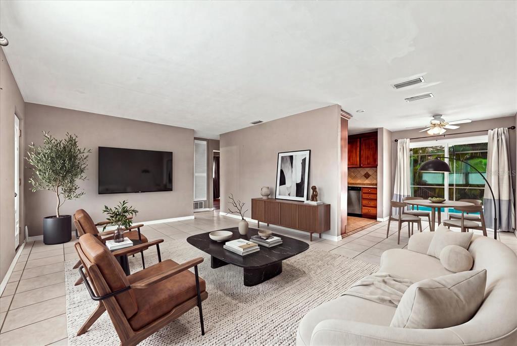 A living room features a curved sofa, leather armchairs, a coffee table, and a dining area — 8380 52ND LANE N, PINELLAS PARK, FL
