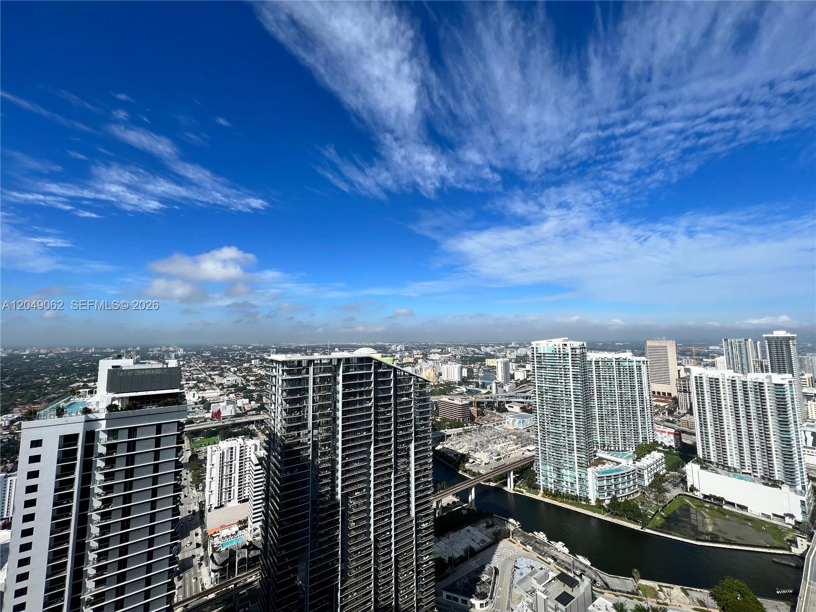 An elevated view of a city skyline featuring several modern high-rise buildings and a canal — 801 S Miami Ave # 5309, Miami FL 33130, MIAMI, FL